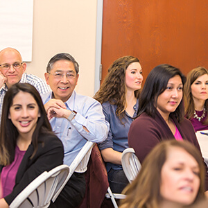 West Yost staff, looking happy, listening to a speaker