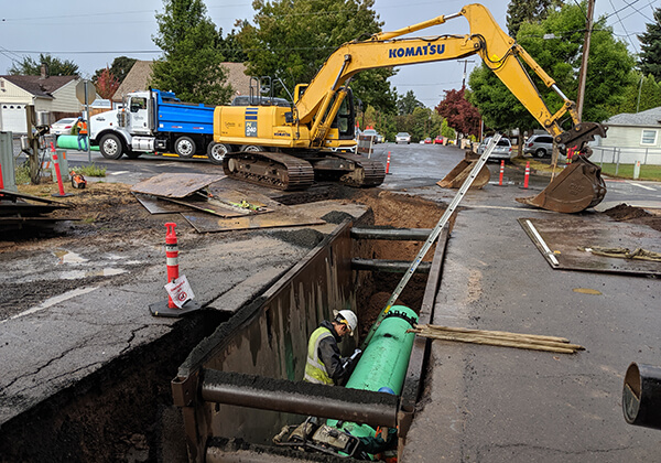 Riverfront Interceptor sewer installation, trench in the middle of a street with pipeline lowered in