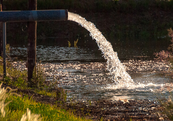 water coming from a pipe into a river