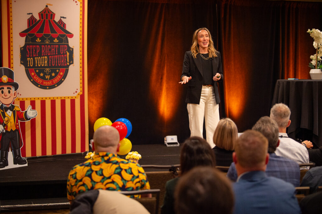 Erin Stafford on stage speaking to the West Yost team. 
